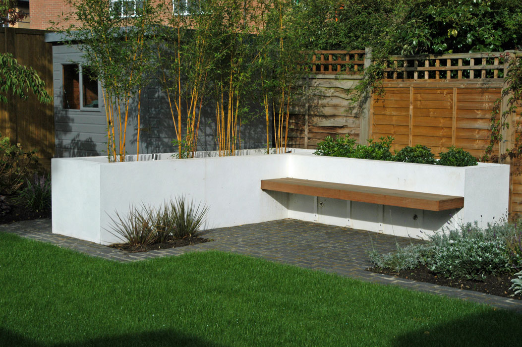 Raised bed with bamboo to screen the shed and a cantilevered bench to create a secluded seating area